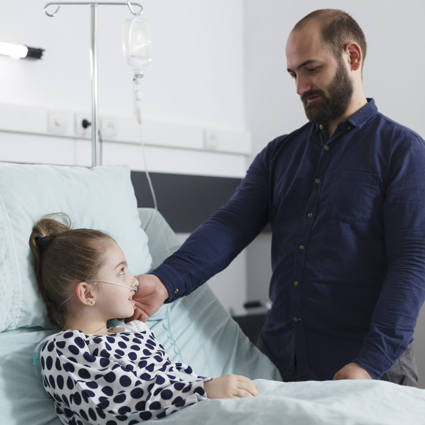 Father touching the cheek of his sick daughter
